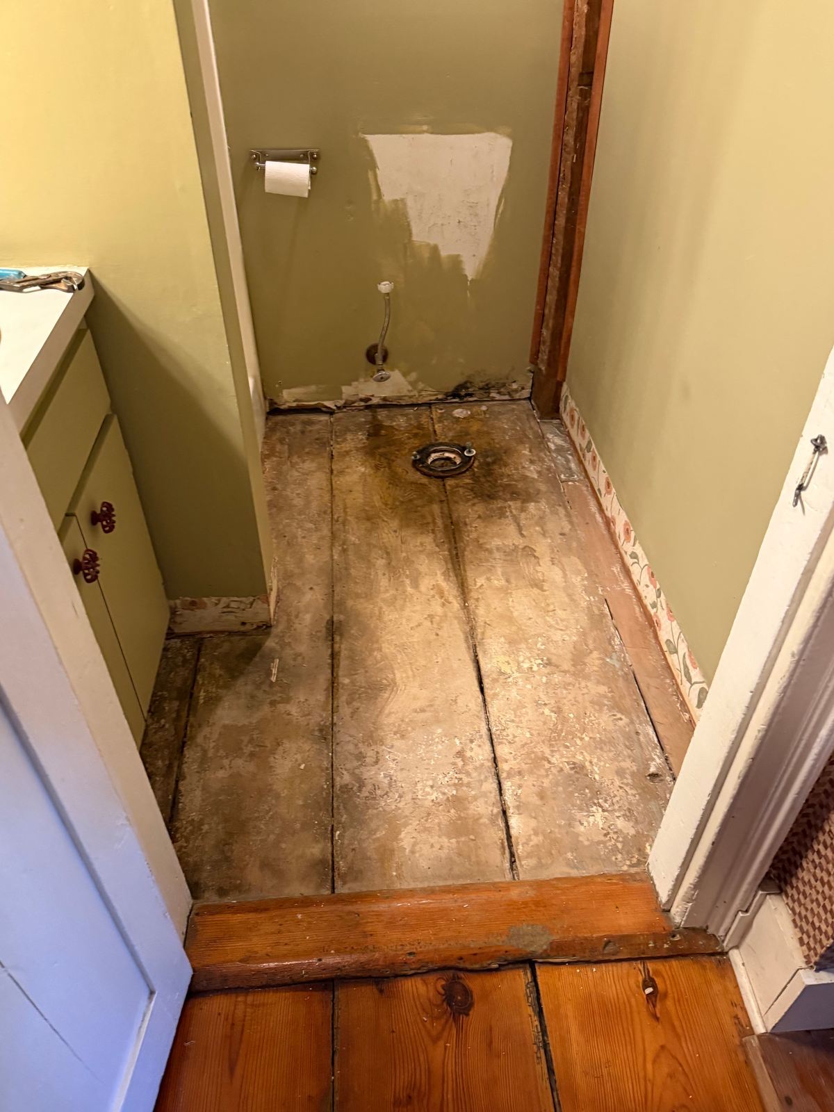 Bathroom floor with damaged subfloor and toilet removed
