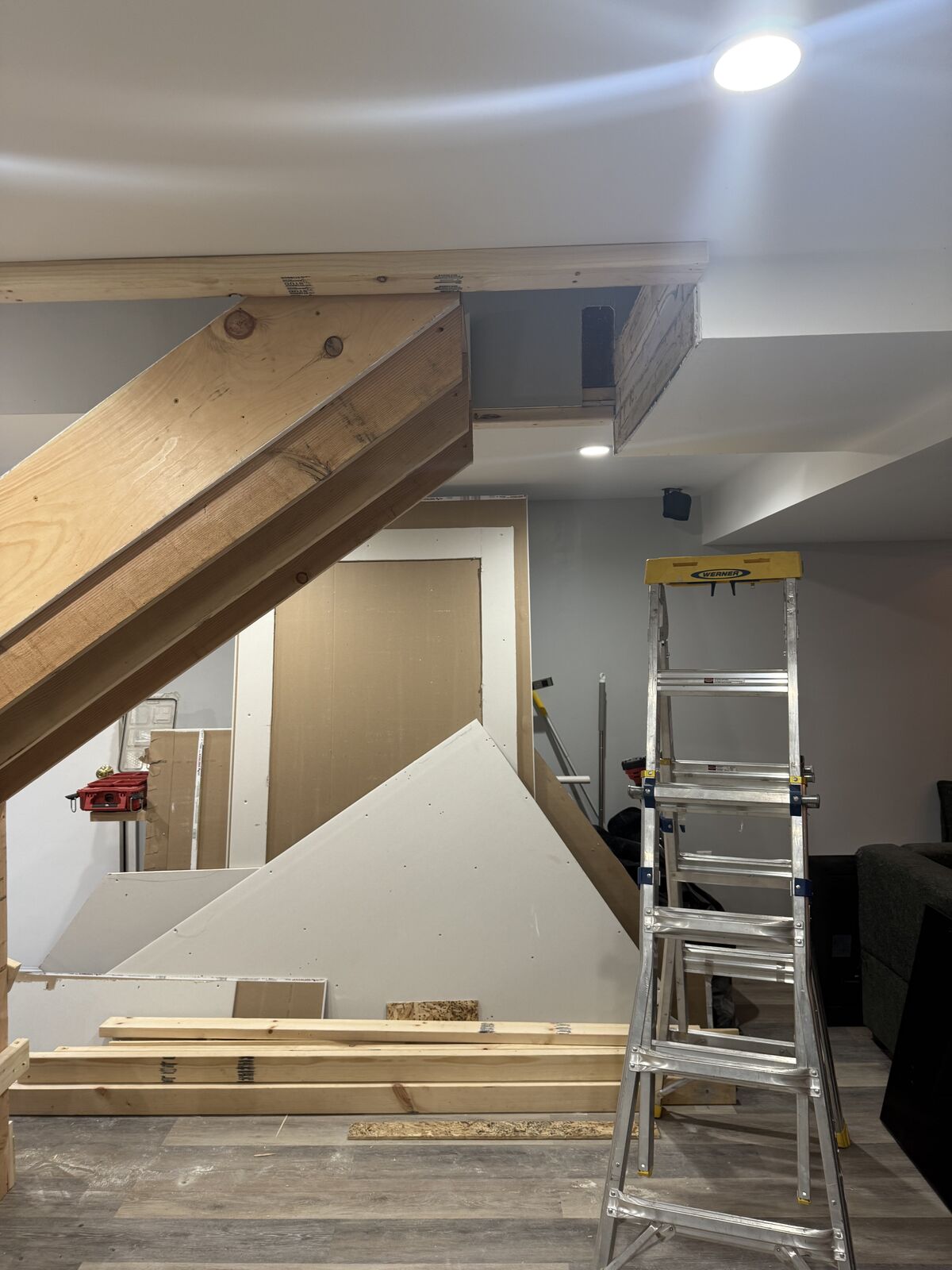 Drywall going up under a basement staircase