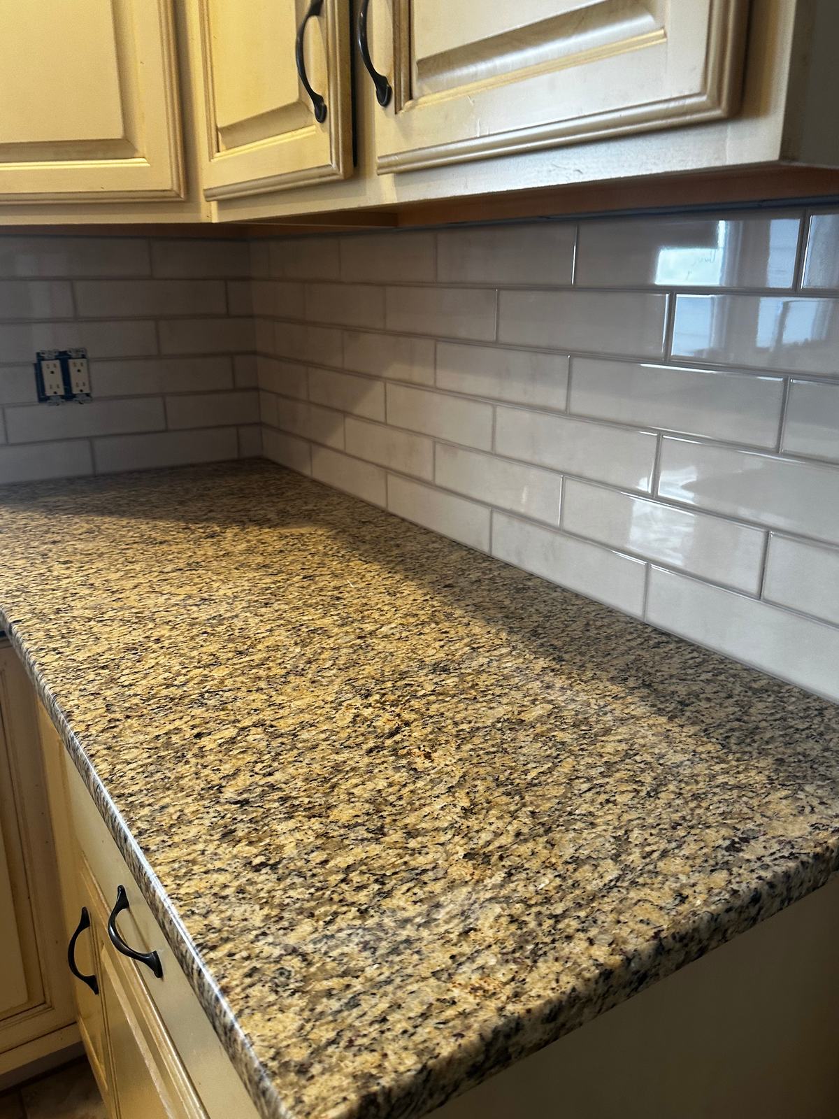 Granite countertop with white subway tile backsplash